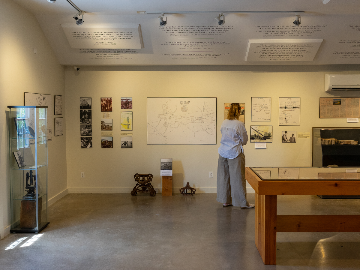 A wide view of the Interpretive Centre gallery — historic quotes about Oak Island line the top of the wall above a large framed map of the island