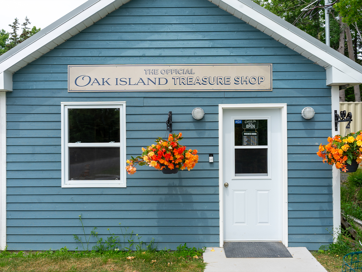 Storefront of the Official Oak Island Treasure Shop — its own blue-clapboard building on site